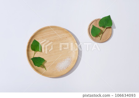 Fresh fish mint leaves and bath salts on wooden plate isolated on white background. Minimal background with copy space for cosmetics, business branding and product presentation of fish mint extract 106634093