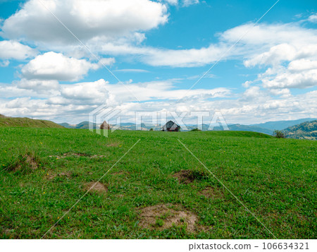 Village in Zakarpattya region with old authentic wooden houses Carpathian mountains view Ukraine Europe. Cottagecore Village in Zakarpattya region with old authentic wooden houses Carpathian mountains view Ukraine Europe. Cottagecore 106634321