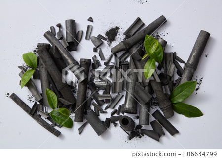 The composition includes bamboo charcoal and tea leaves. Top view, concept for cosmetic product presentation. Natural extracts are widely used in facial cleansers and cleansing products 106634799