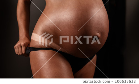 Pregnant woman pulls back her panties showing instant tan. Pregnant woman pulls back her panties showing instant tan. 106635638