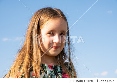 Portrait of a beautiful 5 or 6 year old girl against the sky, copy space for text 106635897