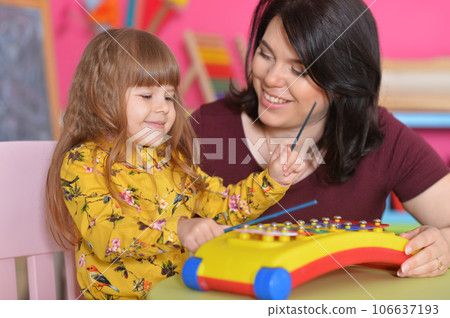 Young mother and cute little son playing with music toy at home 106637193