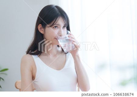 A woman drinking water A woman drinking water 106638674