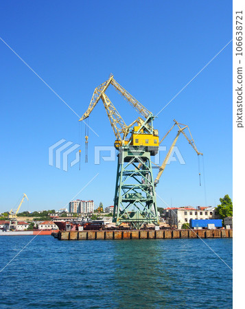 Portal, transshipment crane on the pier of the sea, cargo port. Terminal sea, cargo port. Portal, transshipment crane on the pier of the sea, cargo port. Terminal sea, cargo port. 106638721