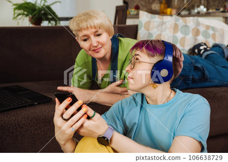 Daughter teaches her elderly mother how to use smartphone to listen to podcasts Daughter teaches her elderly mother how to use smartphone to listen to podcasts 106638729