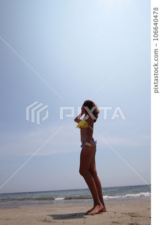 夏天的形象,穿著比基尼的女人站在沙灘上 夏天的形象,穿著比基尼的女人站在沙灘上 106640478