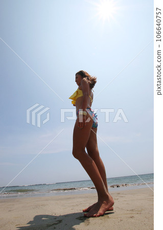 夏天的形象,穿著比基尼的女人站在沙灘上 夏天的形象,穿著比基尼的女人站在沙灘上 106640757