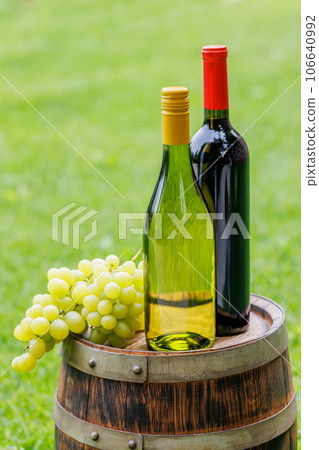 Wine bottles and grape on barrel 106640992