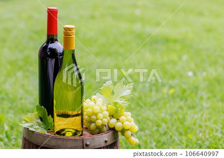 Wine bottles and grape on barrel Wine bottles and grape on barrel 106640997