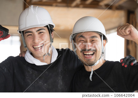 Workers working at a construction site smiling with their shoulders crossed Close-up of Yay 106642004