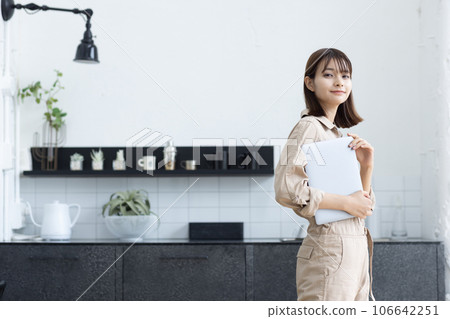 一個穿著工作服的女人站在廚房裡 106642251