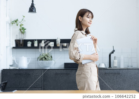 一個穿著工作服的女人站在廚房裡 106642252