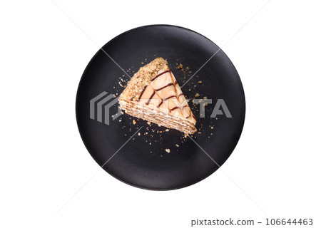 Esterhazy cake sliced on black plate close-up. Delicatessen sweet dessert with almond meringue dough and buttercream Esterhazy cake sliced on black plate close-up. Delicatessen sweet dessert with almond meringue dough and buttercream 106644463
