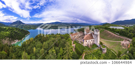 most famous and beautiful medieval castles of northern Italy. scenic Cles  castel- in Trentino , province of Trento. surrouded by fields of apple trees near the lake Santa Giustina 106644984