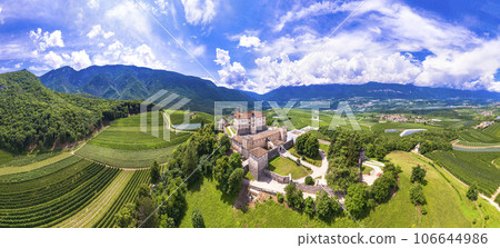Medieval beautiful castles of northern Italy  - splendid Thun castel amongst the apple trees of Val di Non. Trentino region, Trento province.  Aerial drone panoramic view 106644986