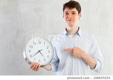 Man with a round big clock in his hands expresses various emotions 106645034