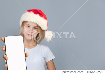 Adorable Christmas girl Santa with smartphone on gray background 106645259