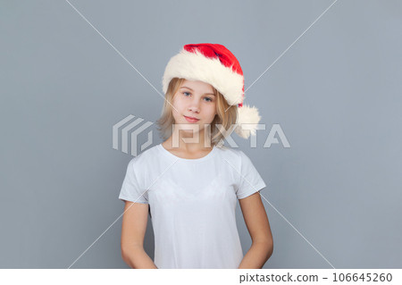 Cute young girl Santa on blue background, Christmas portrait 106645260
