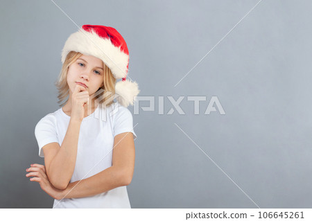 Young girl Santa thinking on light blue background Young girl Santa thinking on light blue background 106645261