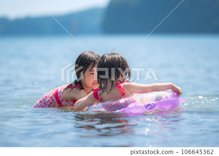 Sisters enjoying swimming in the summer sea Sisters enjoying swimming in the summer sea 106645362