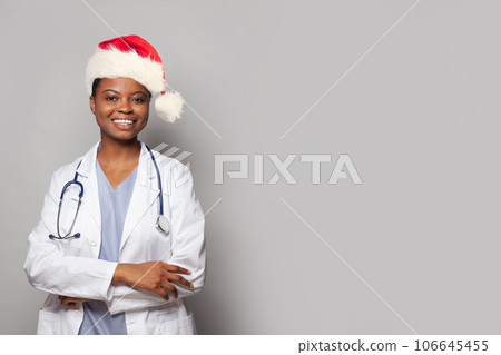 Happy smiling doctor in red Santa hat on white background Happy smiling doctor in red Santa hat on white background 106645455
