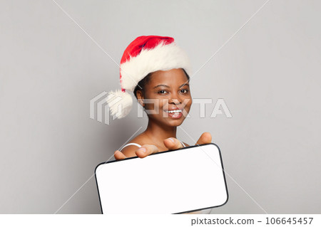 Christmas portrait of Happy Santa model woman with smartphone Christmas portrait of Happy Santa model woman with smartphone 106645457