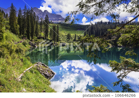 Idyllic nature scenery- trasparent mountain lake Carezza surrounded by Dolomites rocks- one of the most beautiful lakes of Alps. South Tyrol region. Italy Idyllic nature scenery- trasparent mountain lake Carezza surrounded by Dolomites rocks- one of the most beautiful lakes of Alps. South Tyrol region. Italy 106646266