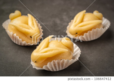 Portuguese marzipan delicacy in the shape a yellow rabbit. Gourmet sweets from the Algarve Portugal on a marble background close-up. 106647412