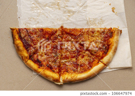 Piece of pizza in cardboard pizza box. Pizza box with leftowers. Top view 106647974