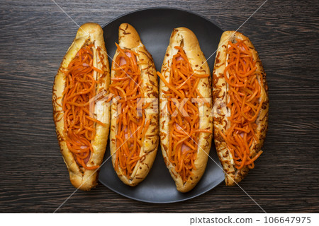 Tasty hot dogs on a black plate on a wooden background. Top view, copy space 106647975