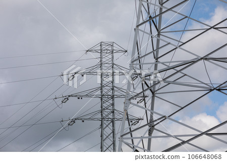 A fragment of a high voltage line against a sky with dark clouds. 106648068