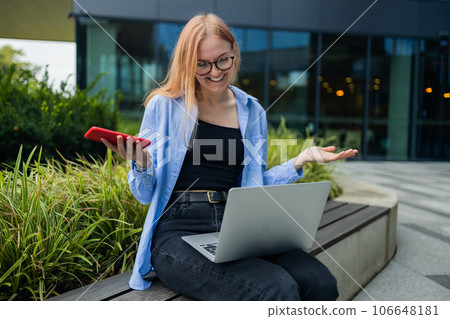 Frustrated business woman received bad news in e-mail on mobile phone while sits outside company near copy space. Disappointed female manager reading problem text message on cellphone  106648181