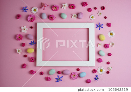 Creative Easter composition. Easter eggs, flowers, photo frame on pink background. Flat lay, top view, copy space, mock up. Creative Easter composition. Easter eggs, flowers, photo frame on pink background. Flat lay, top view, copy space, mock up. 106648219