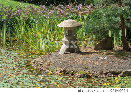 stone lantern on a small island in the middle of a pond in a Japanese garden 106649064