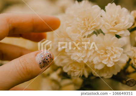 Creamy yellow miniature roses, fragrant buds in female hand. Woman touching flowering buds on shrub in a spring summer garden. Floral greeting card. Roses on a twig, branch on green natural background Creamy yellow miniature roses, fragrant buds in female hand. Woman touching flowering buds on shrub in a spring summer garden. Floral greeting card. Roses on a twig, branch on green natural background 106649351