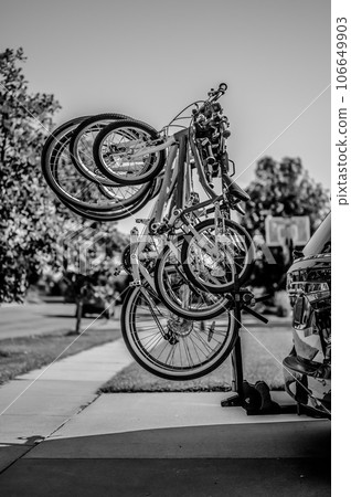 vertical mounted bikes on a vehicle carrier attached to a trailer hitch.  106649903
