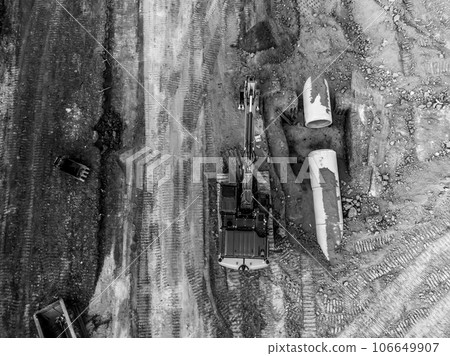 Excavator next to an open trench with two culverts ready for a connection juncture.  106649907