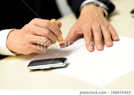 Businessman's hand pushing a seal 106650483