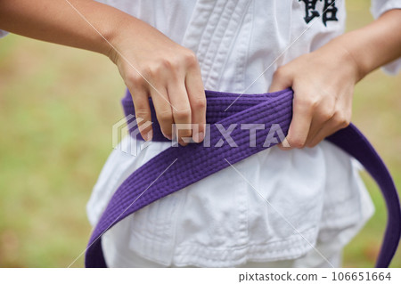 Elementary school girl practicing karate in a midsummer park Elementary school girl practicing karate in a midsummer park 106651664