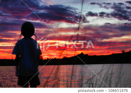 Silhouette of a child playing surf skate on a golden sunshine day Silhouette of a child playing surf skate on a golden sunshine day 106651876