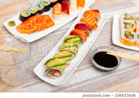 For several guests, Japanese lunch is served - set of uramaki rolls, soy sauce, 106653686