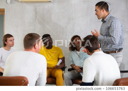 Young man teacher reading lecture for a group of guys 106653763