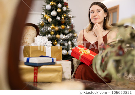Happy young woman prepares Christmas presents 106653831