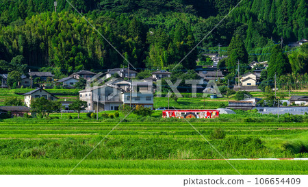 以阿蘇山脈為背景的車站大樓周圍的田園風光和陽光列車【阿蘇下田城親愛溫泉站】“南阿蘇鐵道全線開通” 106654409