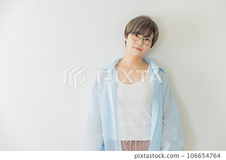 Young woman leaning against a white wall Young woman leaning against a white wall 106654764