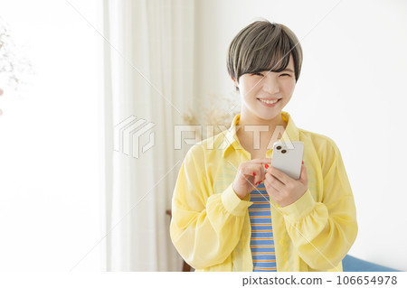 A young woman operating a smartphone A young woman operating a smartphone 106654978