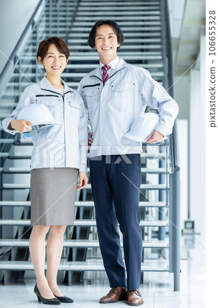 Men and women in work clothes with helmets Men and women in work clothes with helmets 106655328