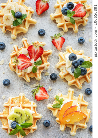 Freshly baked waffles with strawberries and blueberries Freshly baked waffles with strawberries and blueberries 106656891