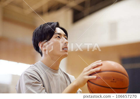 Japanese male university student practicing basketball in the gymnasium Japanese male university student practicing basketball in the gymnasium 106657270