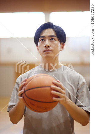 Japanese male university student practicing basketball in the gymnasium Japanese male university student practicing basketball in the gymnasium 106657289